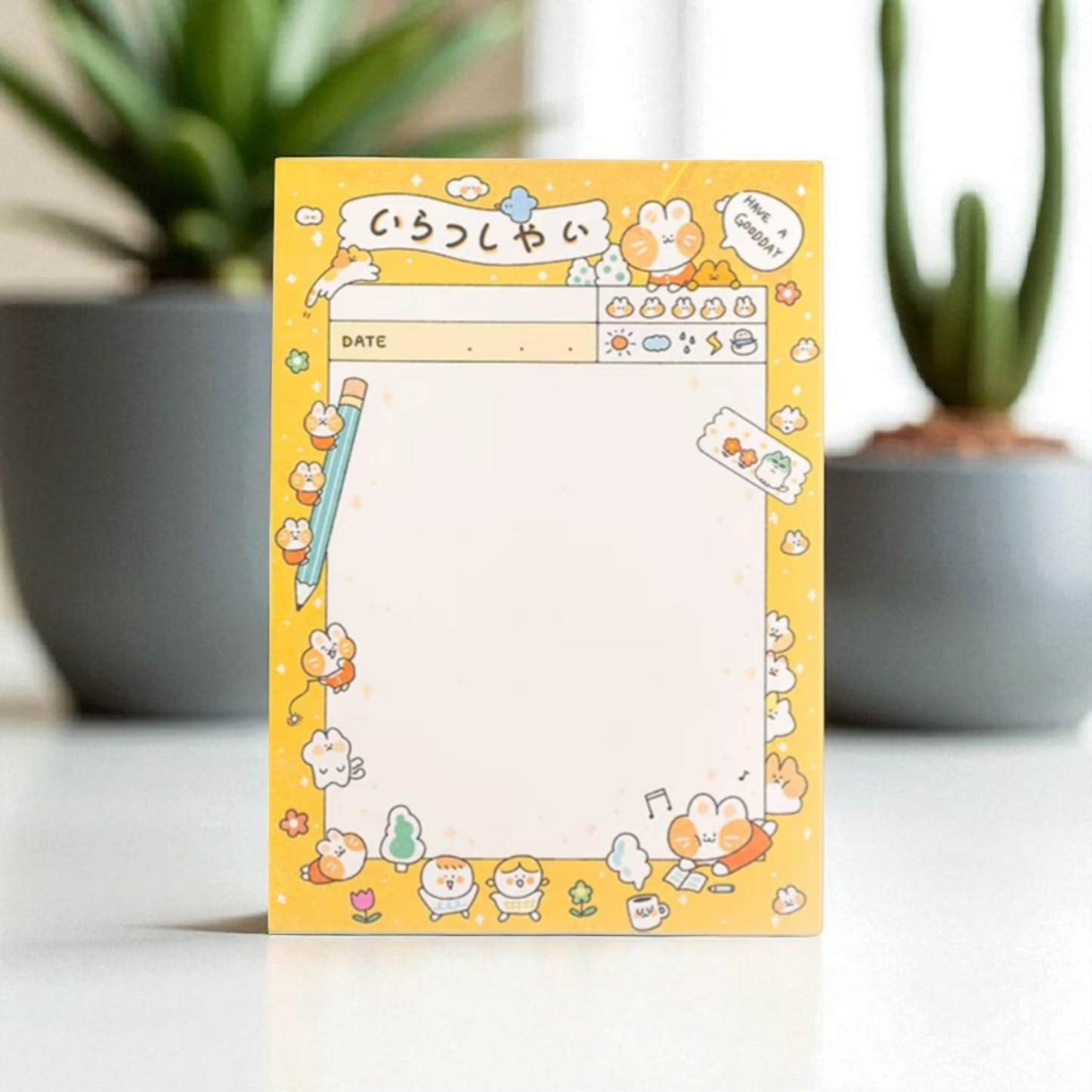 Cute yellow notepad with adorable animal illustrations, space for date and notes, set against a plant backdrop.